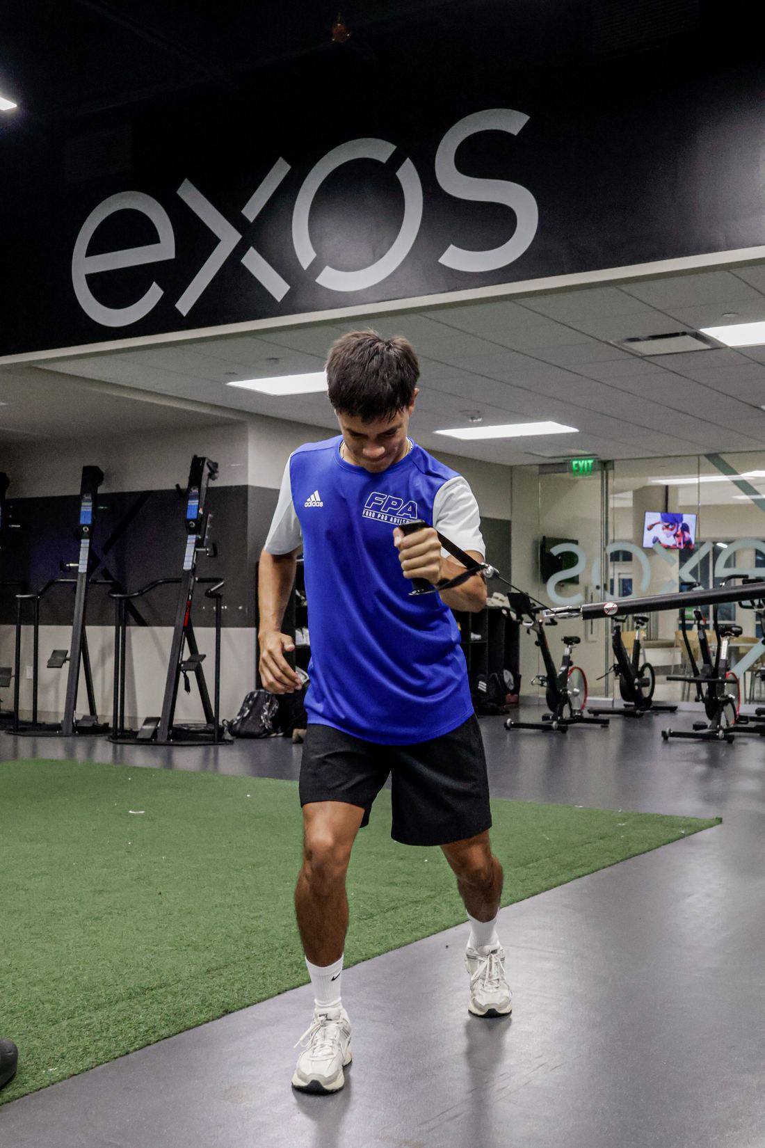 An FPA player working through a movement session beneath the EXOS signage.
