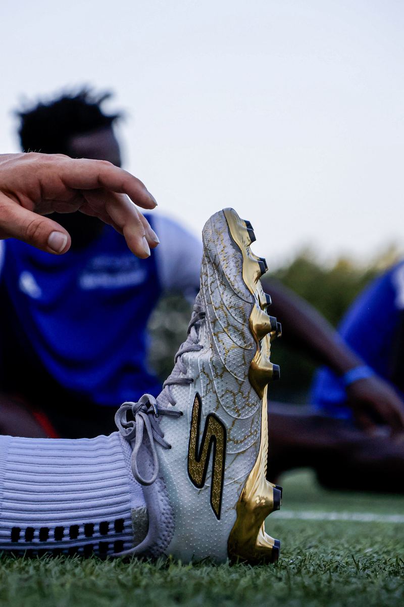 Close detail of a player's boot pitchside before a training session.