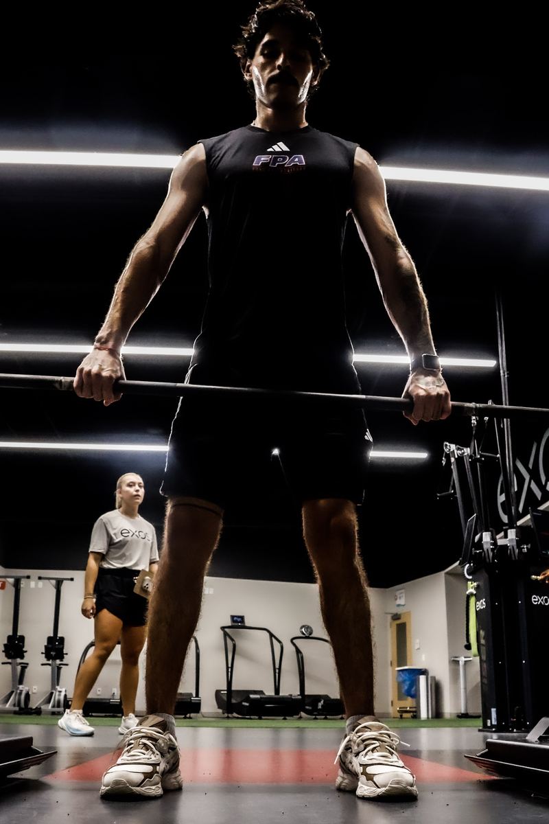 An FPA athlete set up over a barbell during a strength block.